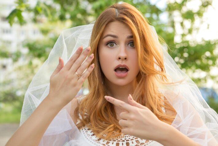 Angst vor der Hochzeit - Braut zeigt erschrocken auf ihren Ring