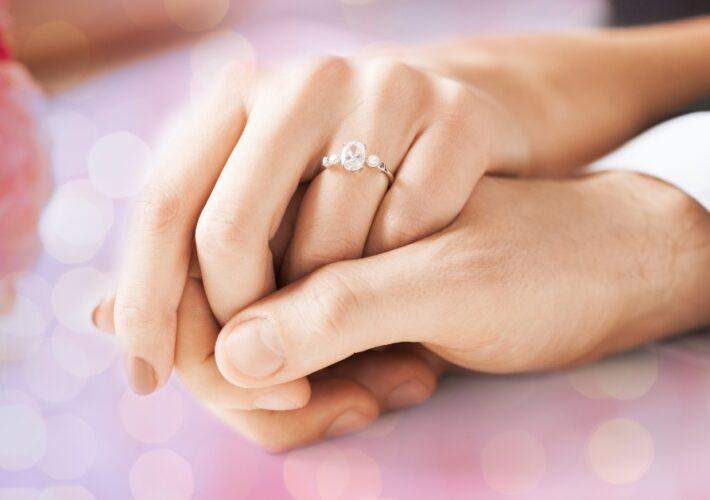 Hände von Mann und Frau, Verlobungsring - Verlobungsfeier