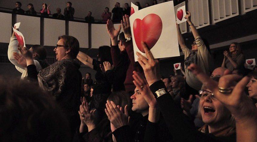 Menschenmenge zeigt Bilder mit Herzen - Flashmob-Heiratsantrag