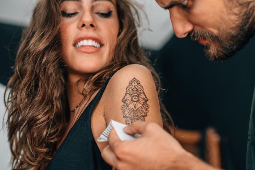 Junge Frau bekommt temporäres Tattoo